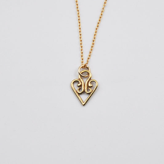 Gold heart-shaped pendant necklace on a light gray background