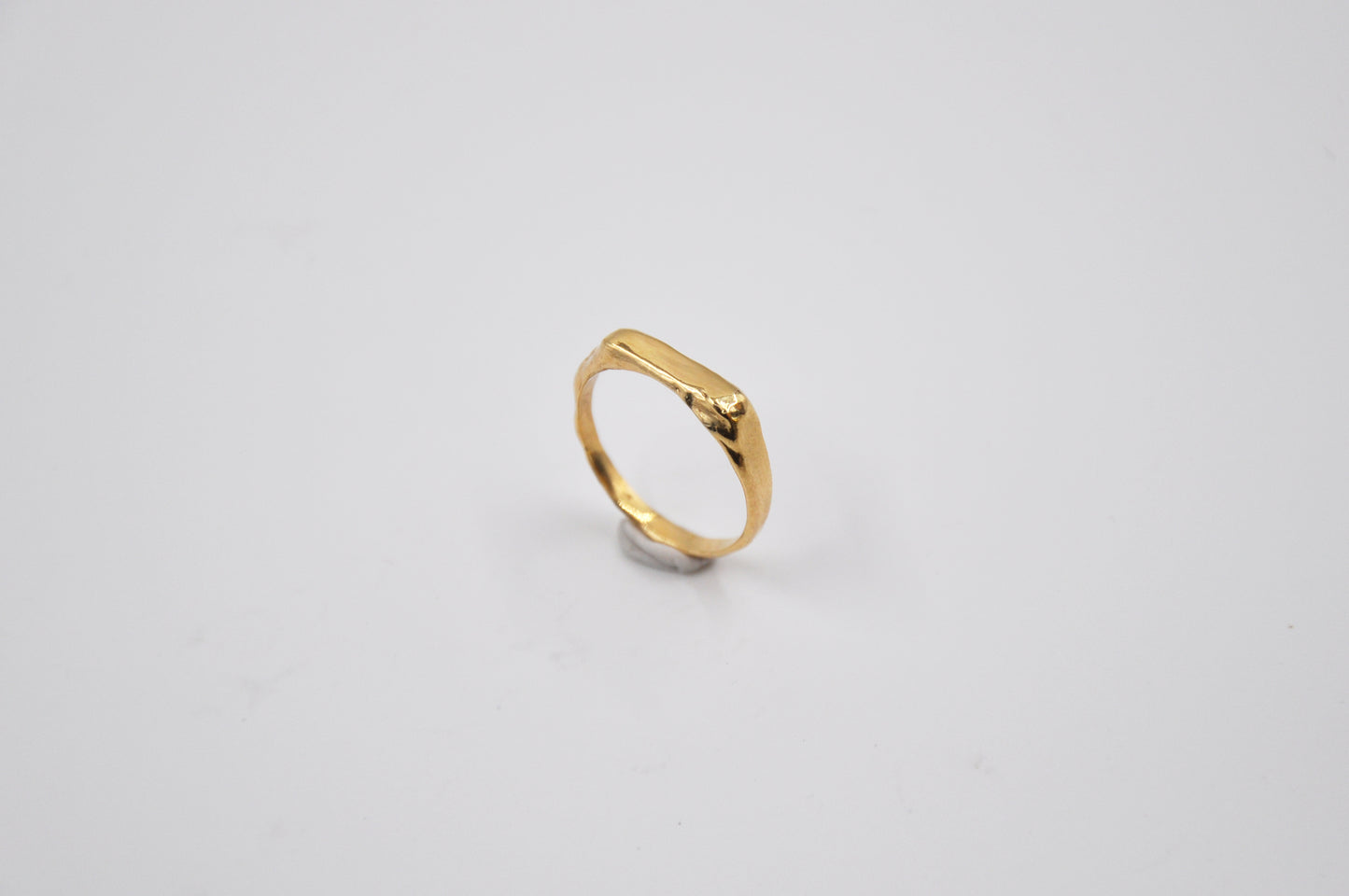 Gold ring on a light gray background