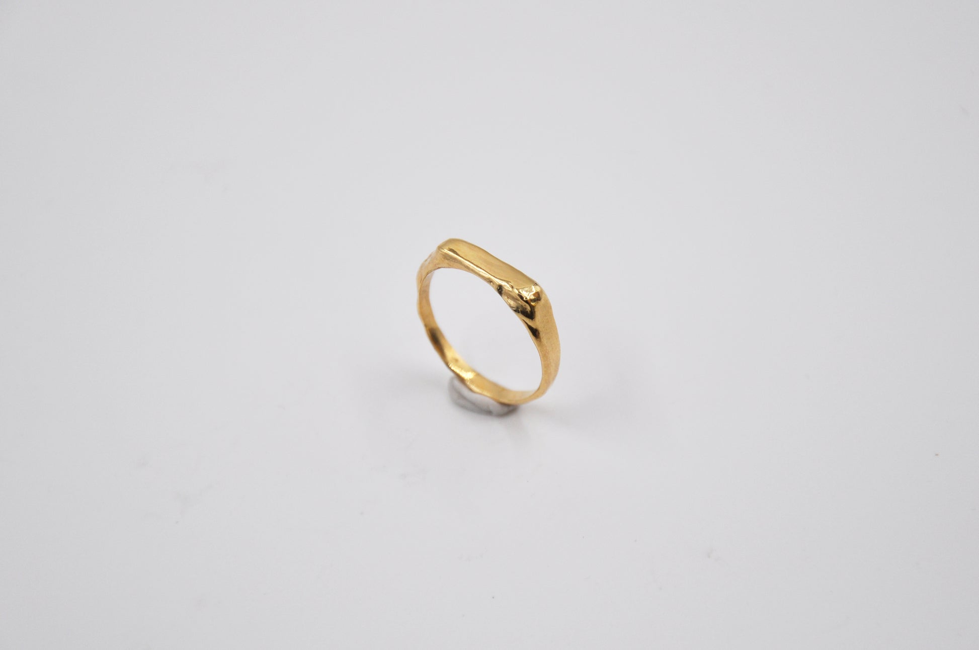 Gold ring on a light gray background