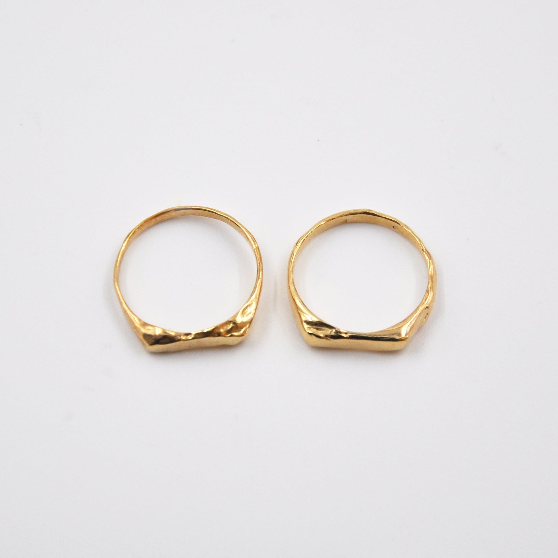 Two gold rings on a white background