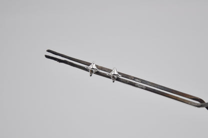 Silver star shaped stud earrings on a gray background