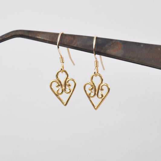 Gold heart-shaped earrings on a white background
