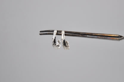 Pair of silver earrings on a gray background