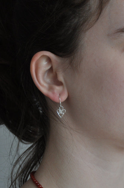 Close-up of a woman wearing a red beaded necklace and silver earrings.