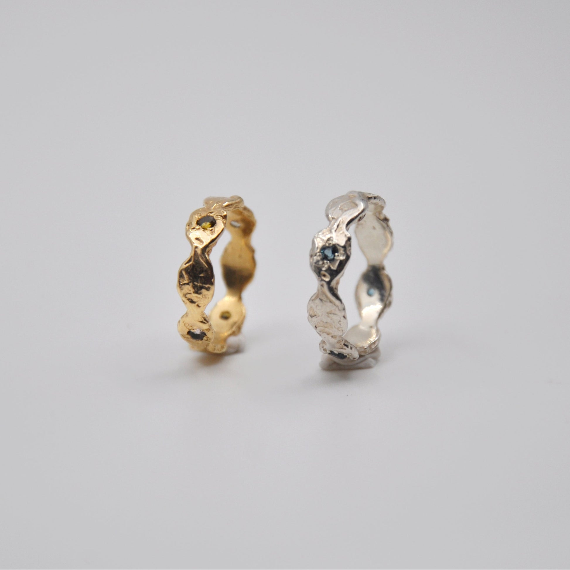 Two gold and silver rings on a gray background